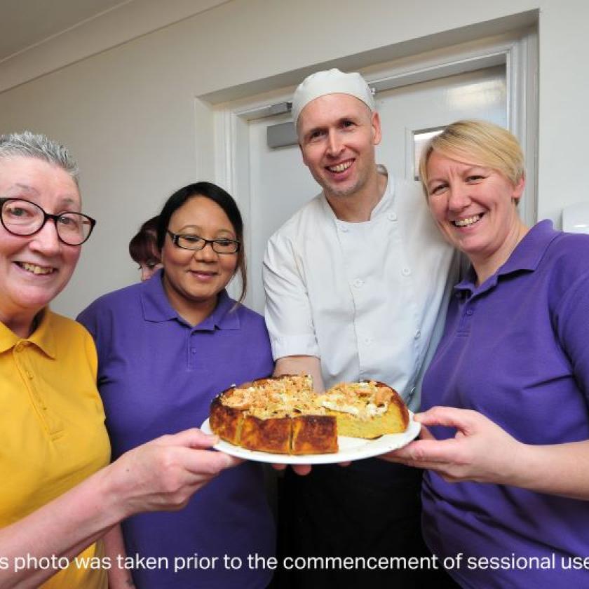 Staff and residents share a cake made by the care home chef, Matthew