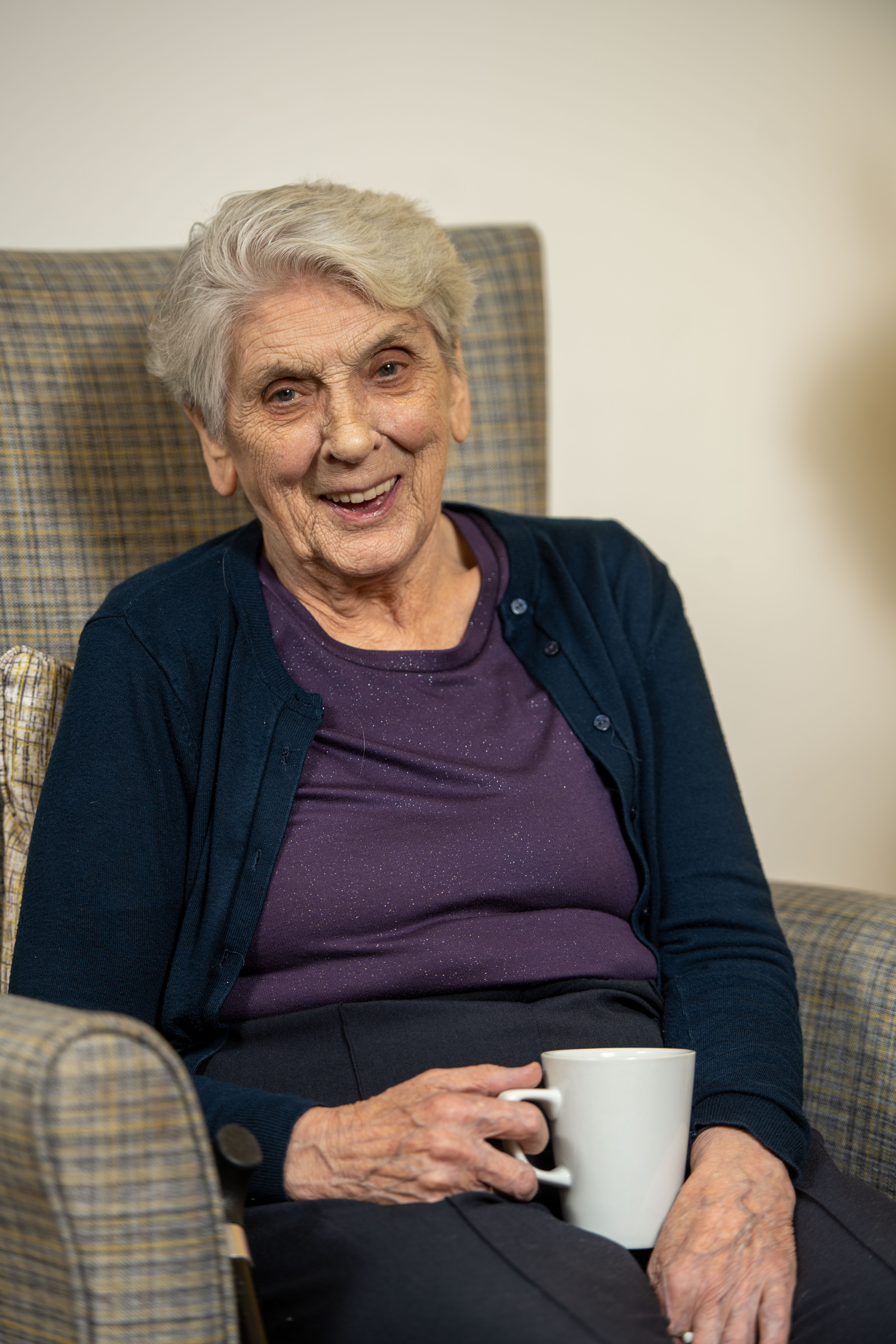 Elderly woman seated smiling 