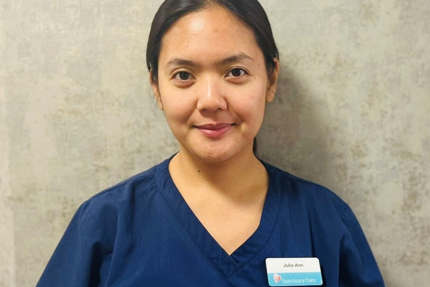 A female care worker smiling into the camera