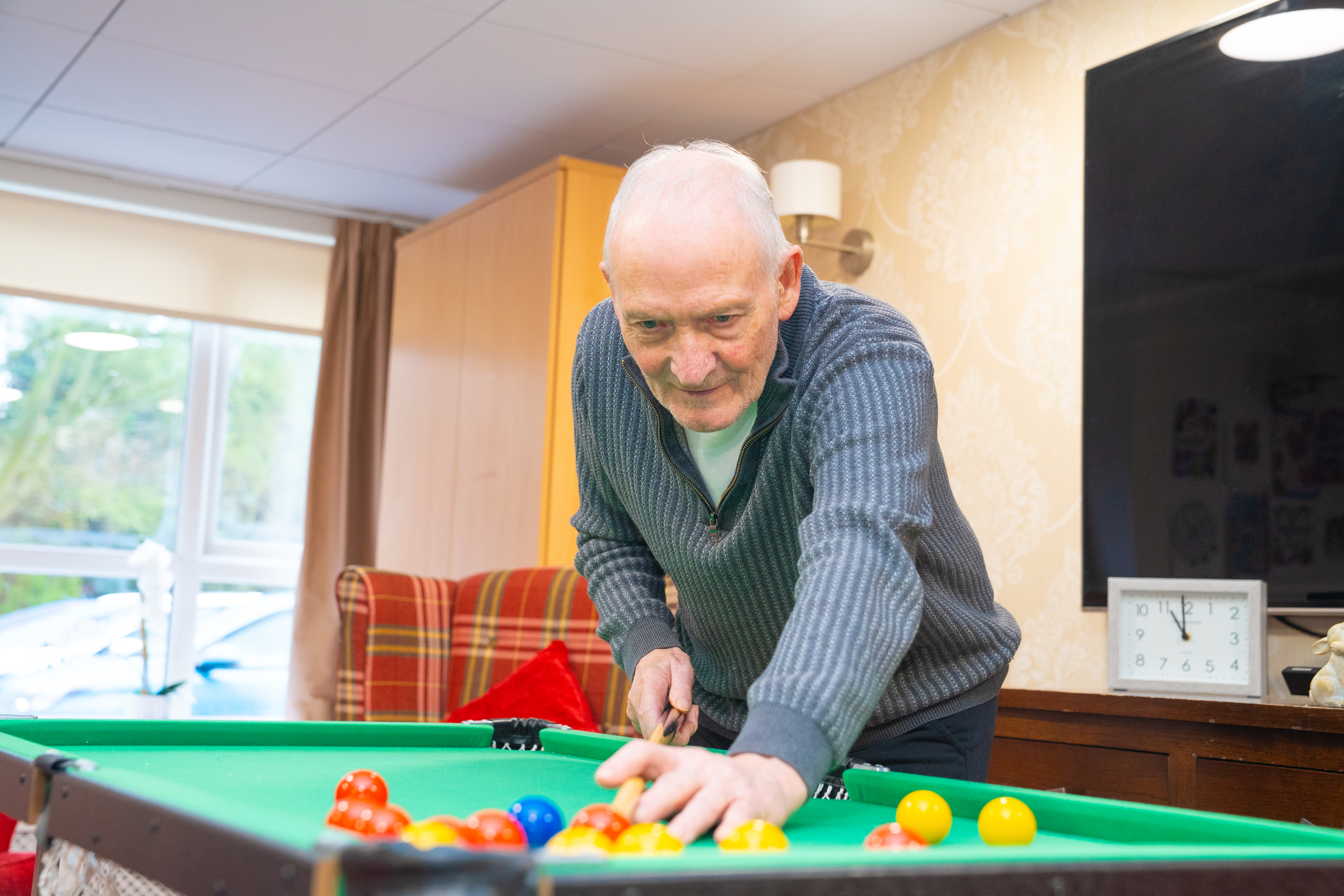 A male resident playing pool