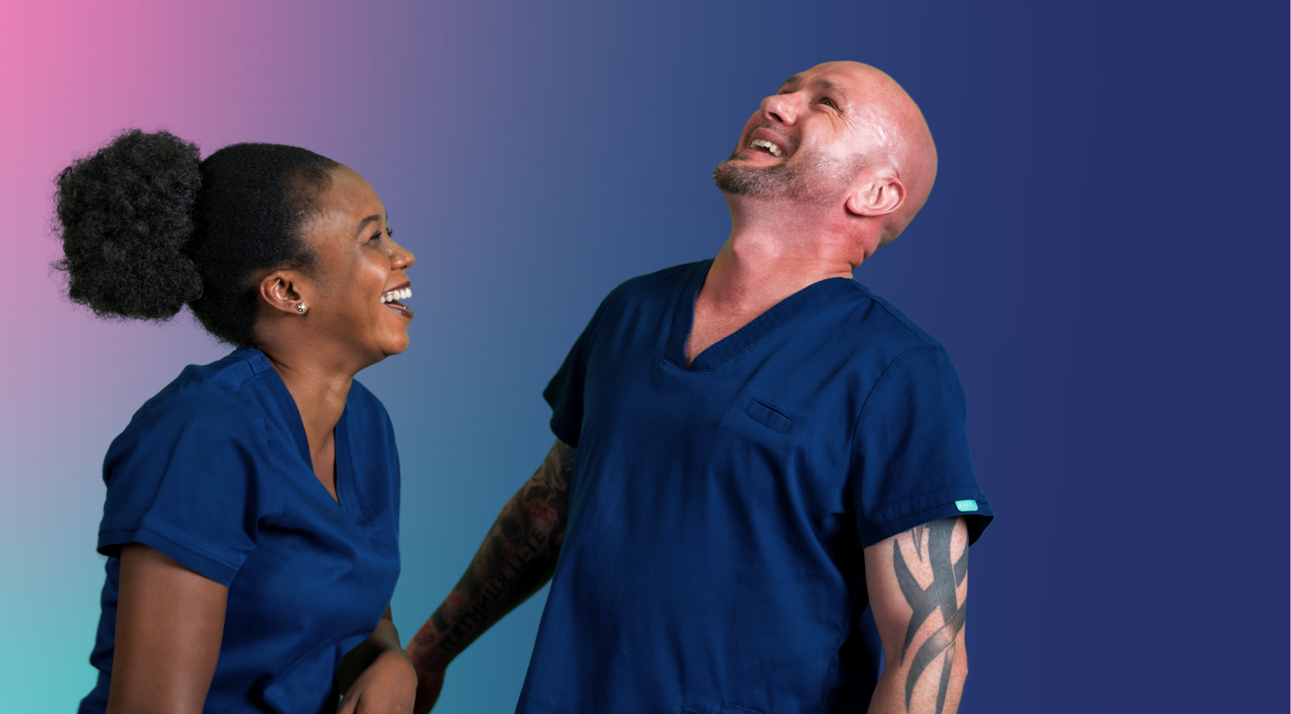 ID23a Jobs nursing careers - Progression pathways made for you Two people in blue nursing uniforms standing together in front of a pink heart-shaped background.