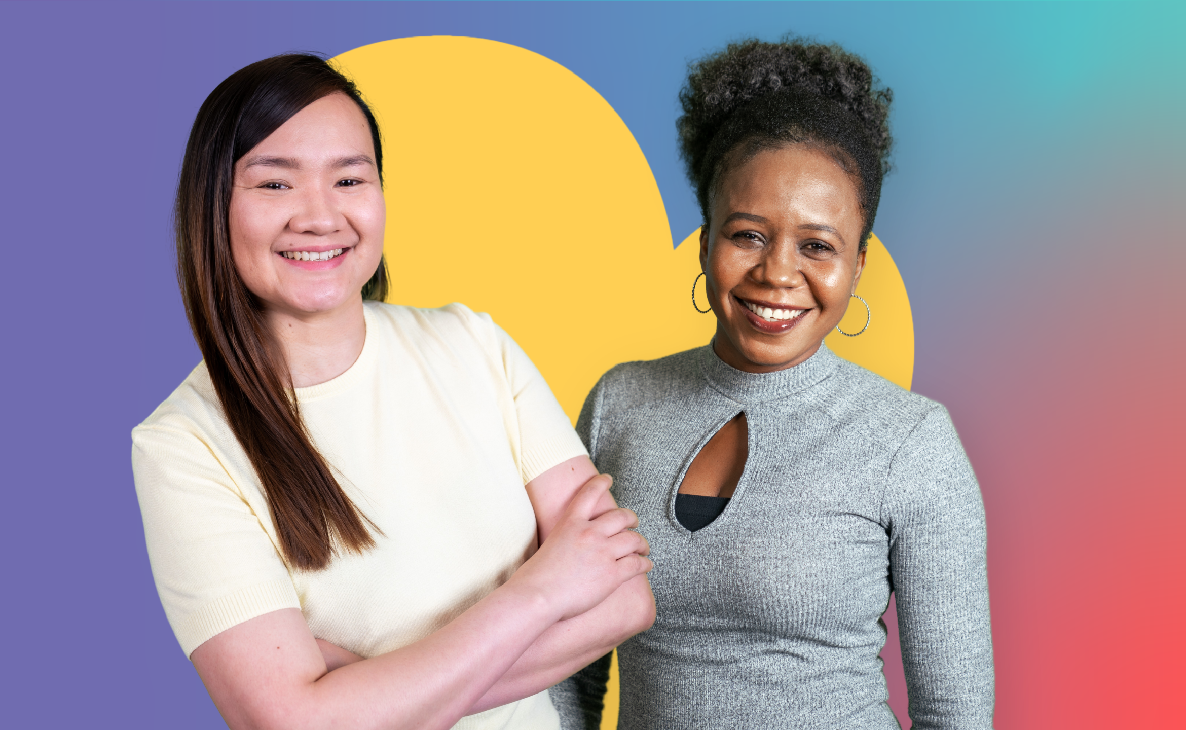 Two people standing in front of a large yellow heart shape on a gradient background. One person has their arms folded while the other is standing beside them. Both are facing the camera.