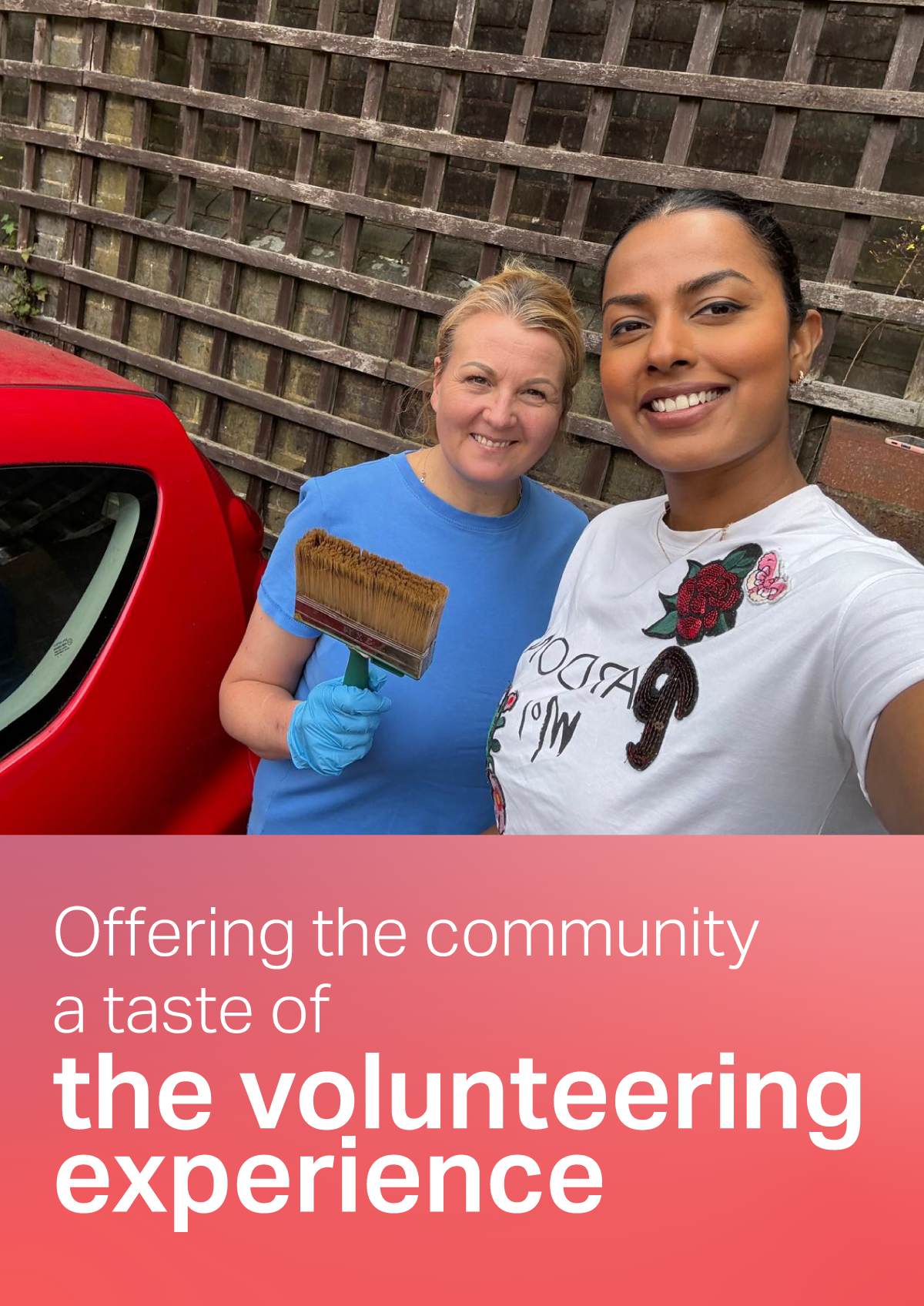 Two people posing for a photograph outdoors beside a red car, with one person holding a paintbrush. Text "Offering the community a taste of the volunteering experience" underneath the picture.