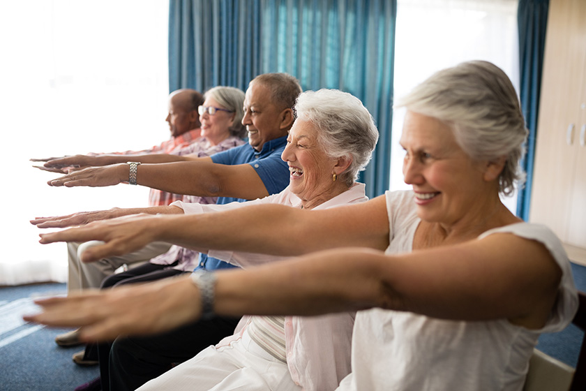 Elderly people doing exercise in a care home