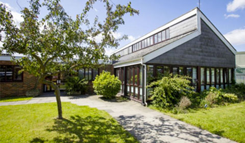 A Sanctuary Care home, with a lawn and a tree in the foreground