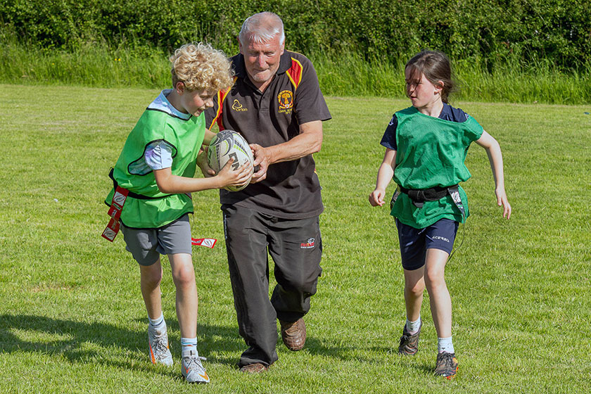 Ron Bruce, Annabel Hughes-McCorkell and Eli Squires playing rugby