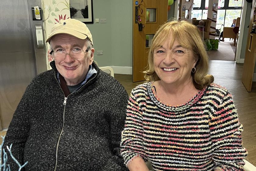 Brother and Sister sit smiling at Care Home