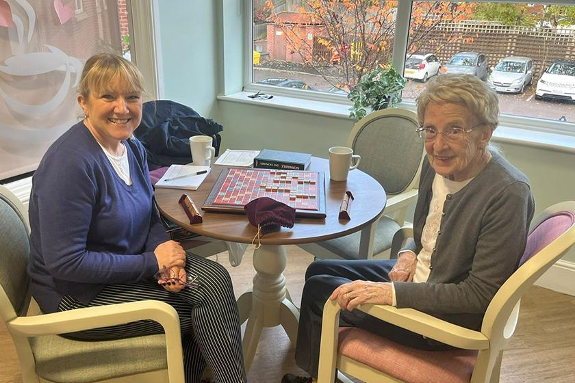 Tracey and her mum at Castlecroft Residential Care Home Mother and Daughter play scrabble smiling