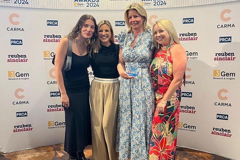 Abby Symons from Sanctuary Care holds award with colleagues from Speed Communications 
