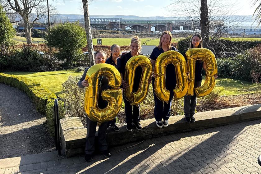 Four Sanctuary Care staff member holding golden balloons that spell the word 'good'