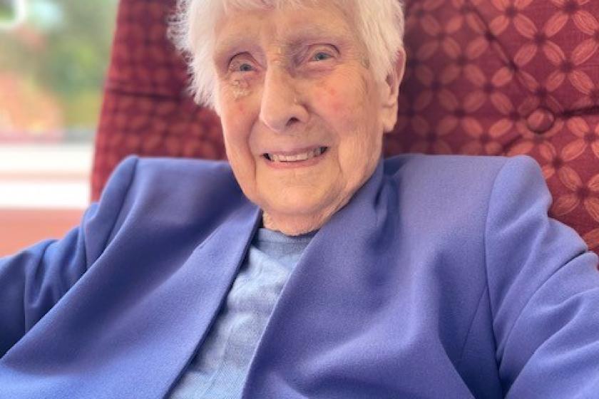 Brambes residential care home resident Lorna, sat smiling in an arm chair