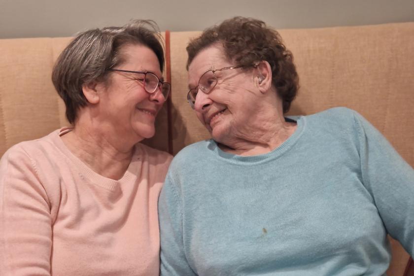 Mature mother and daughter smiling at each other