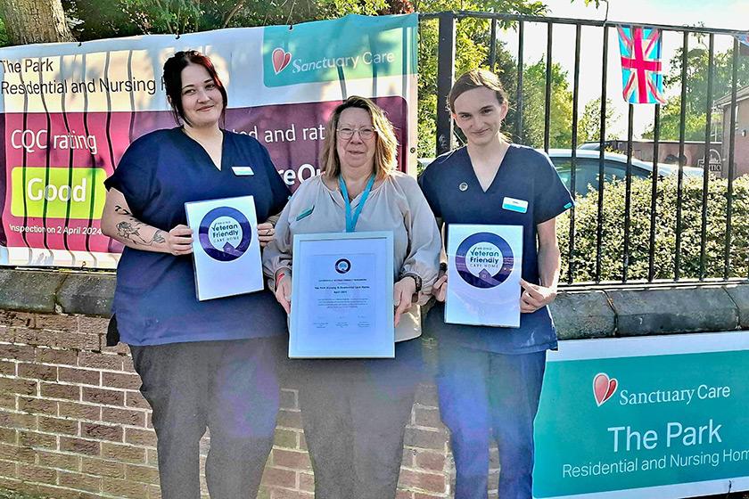 Care home staff at The Park Residential and Nursing Home in Chaddesden stand in front of the care home holding signs celebrating their veteran friendly status