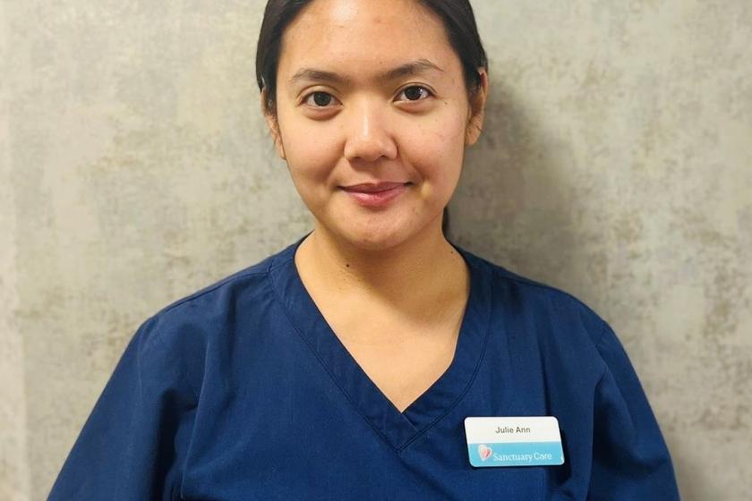 A female care worker smiling into the camera