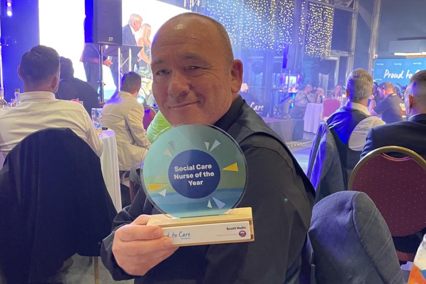 Scott smiles for the camera at the awards ceremony holding his award