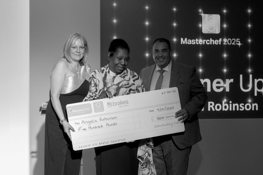 Staff stood together smiling with cheque