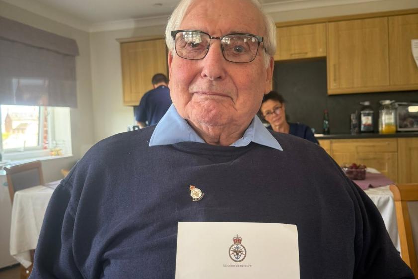 Resident smiling holding badge