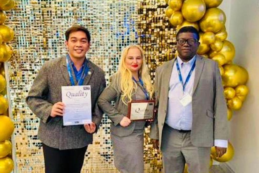 Staff stood together smiling with cheque