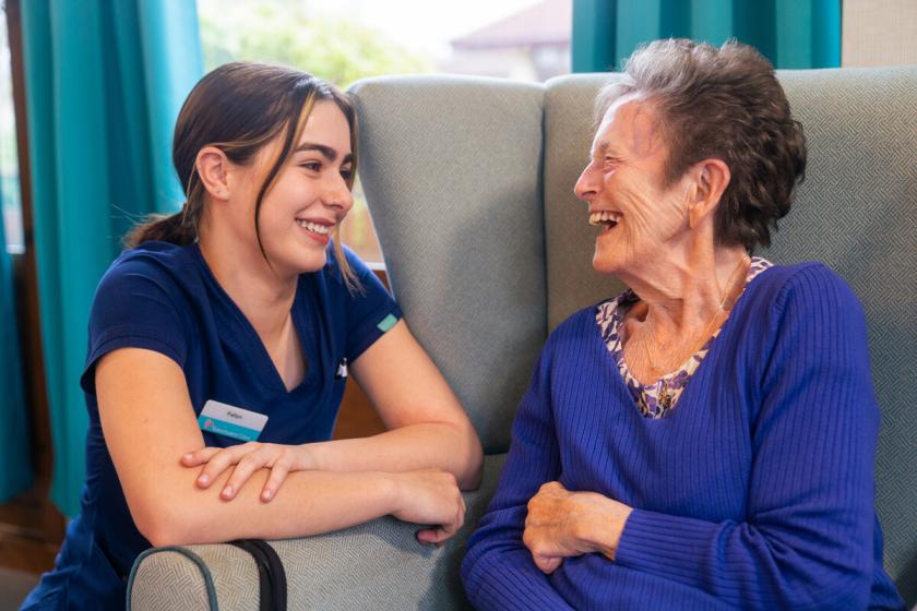 A care worker and a resident having a conversation and laughing together