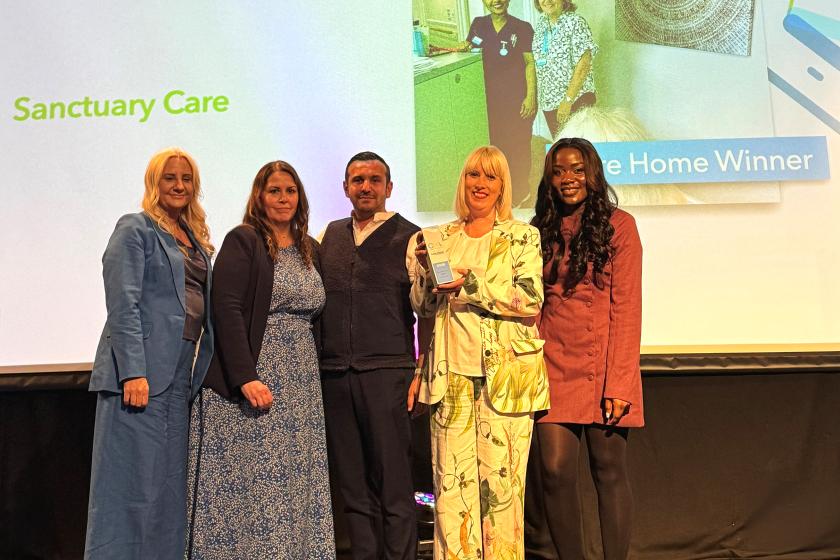 Staff smiling and holding award