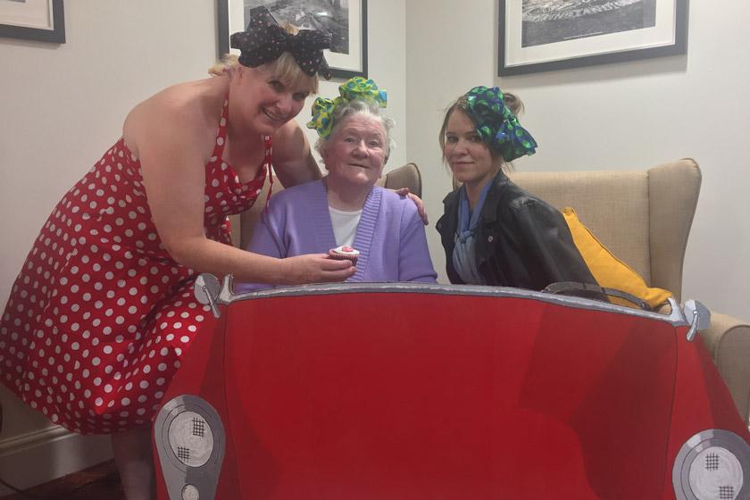 Staff and a resident dressed in 1950s style clothing.