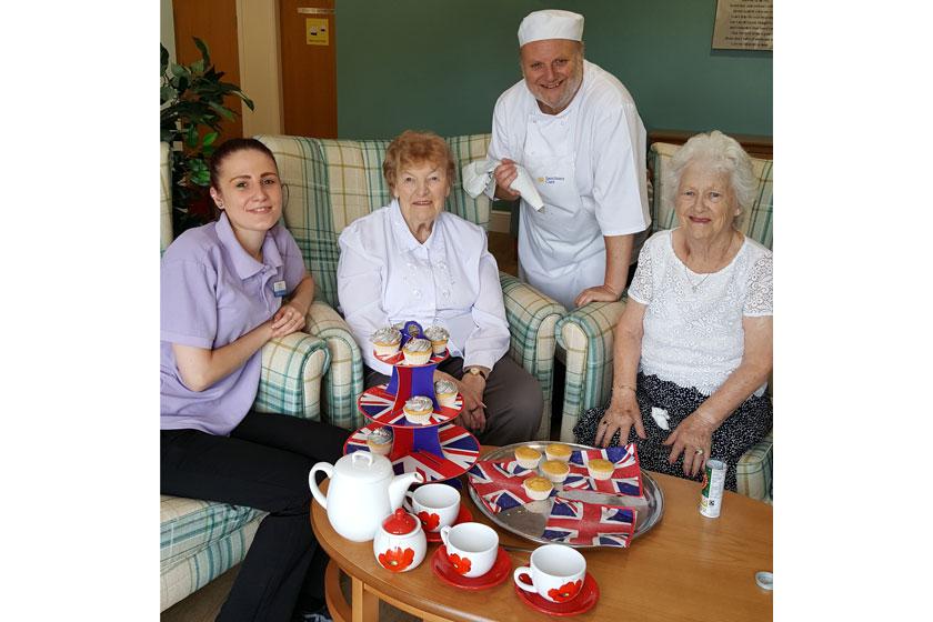 Staff and residents practicing decorating cakes for cupcake day