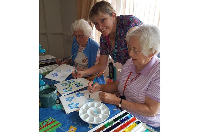 Residents painting flowers.