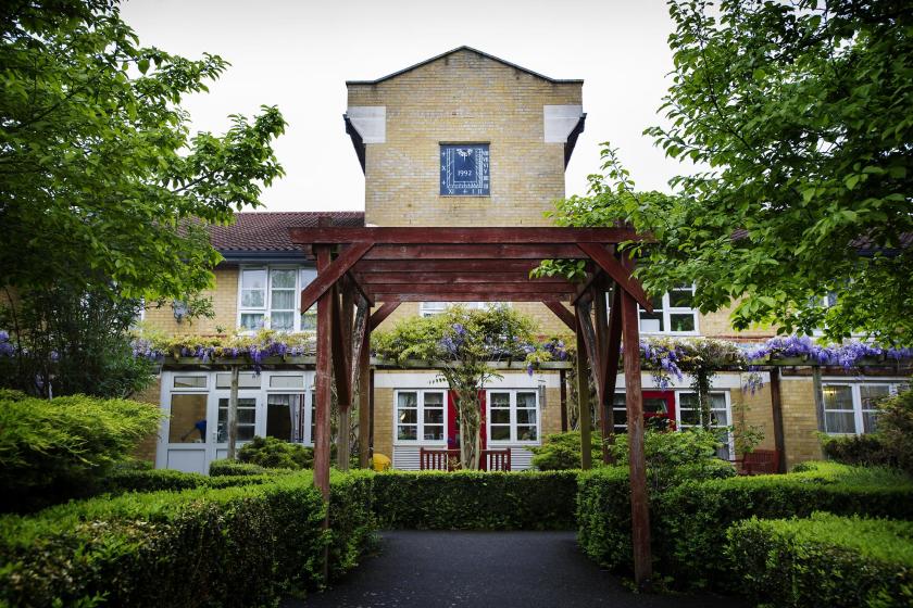 A pergola frames the exterior of Aashna House Care Home in London.