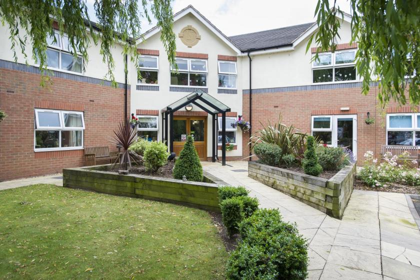 Front exterior of East Park Court Care Home with well-maintained grounds.