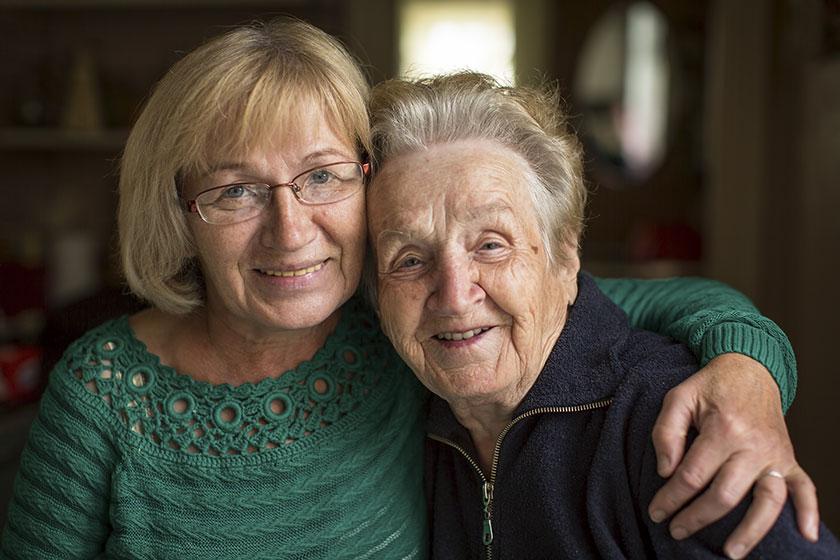 A care home resident and her daughter share an embrace