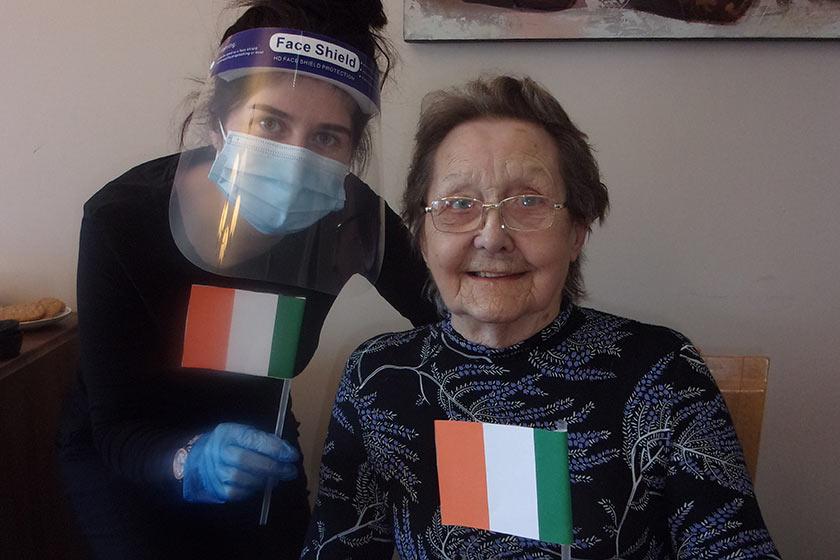 Jessica waves handmade Irish flags with resident, Elsie