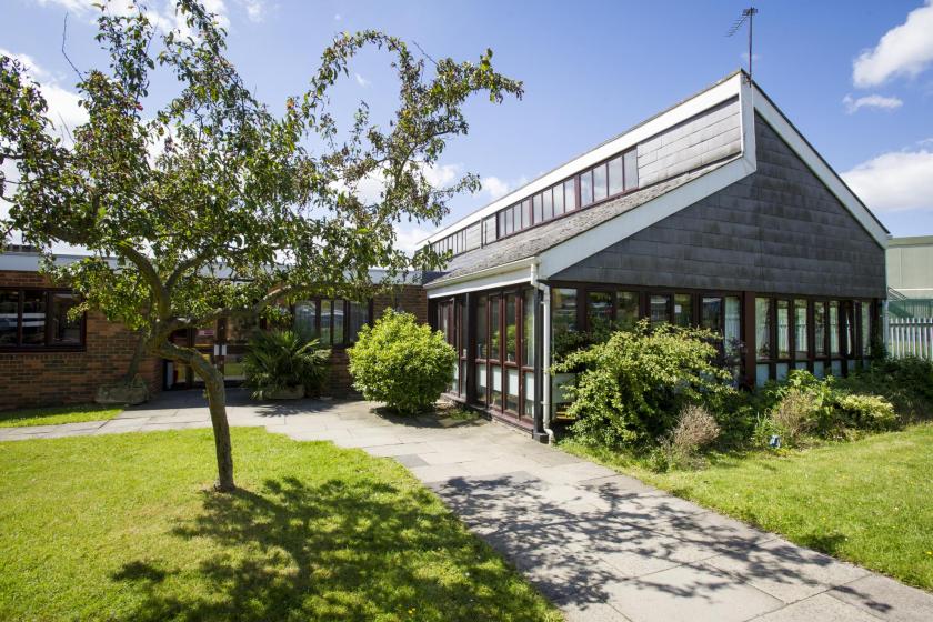 Main entrance of the Pinewood Residential Care Home with a large greenery area.