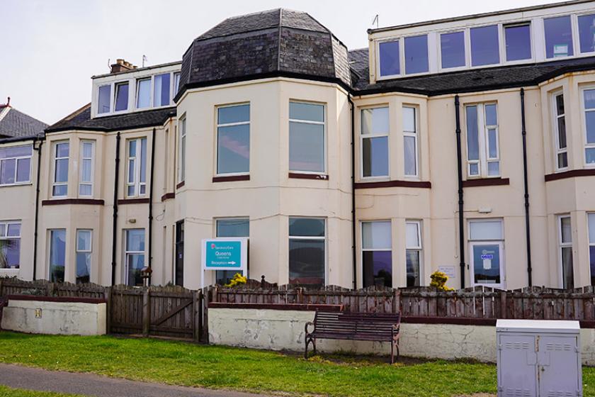 Queens Care Home exterior with a large window front. 