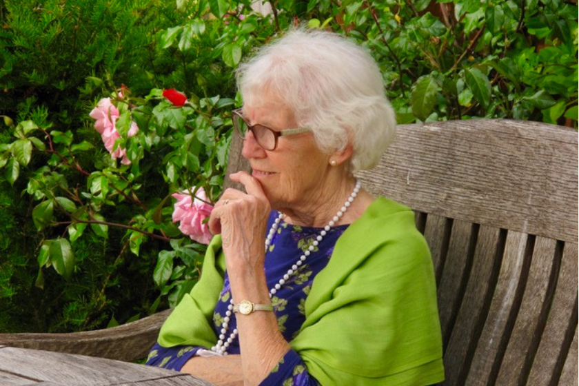 A resident sits in the lovely gardens at Briggs House 