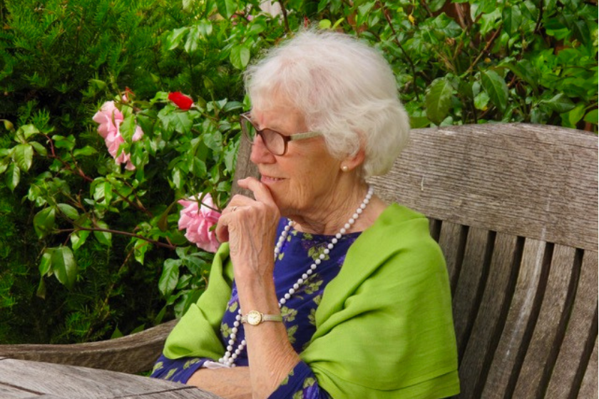 A resident sits in the lovely gardens at Briggs House