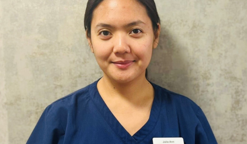 A female care worker smiling into the camera