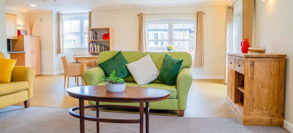 A bright, cosy lounge with comfy seating, natural light, and a homely feel designed for comfort, relaxation, and community.
