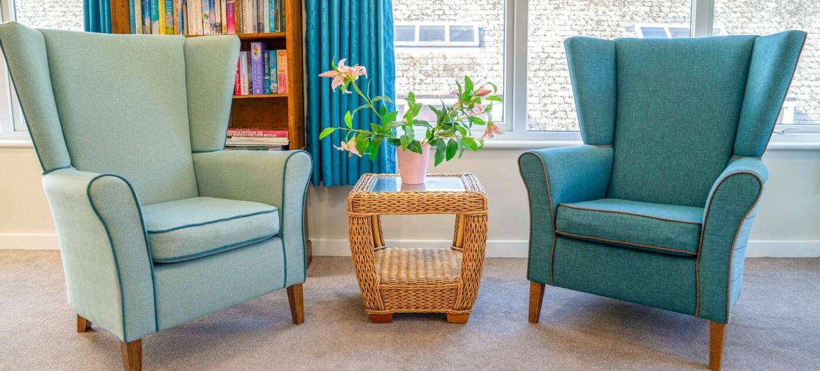 Two oversized arm chairs located next to a large window. 