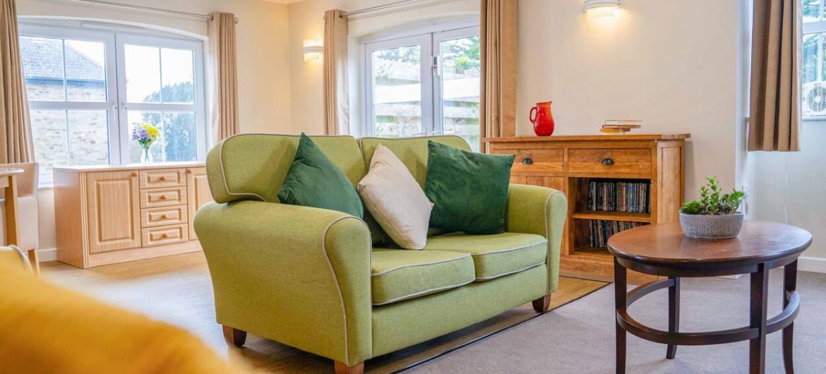 A bright and cosy living room in The Trevern care home, with comfy seating, natural light, and homely touches designed to offer comfort, peace, and a sense of belonging.