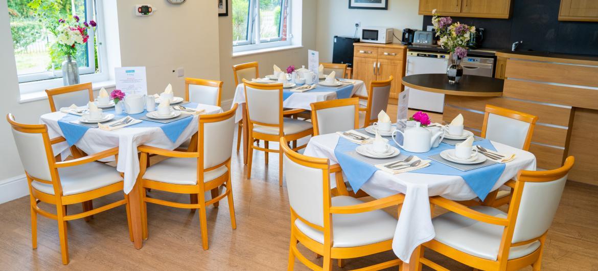A dining room with three dining tables beautifully set with cutlery and crockery