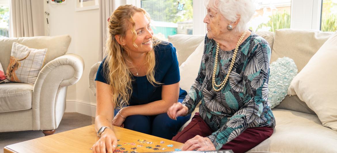 Resident and carer in living room