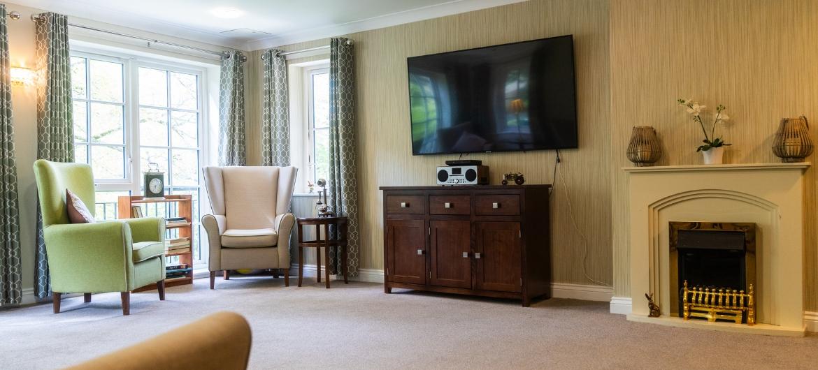 A large lounge with a TV and fireplace