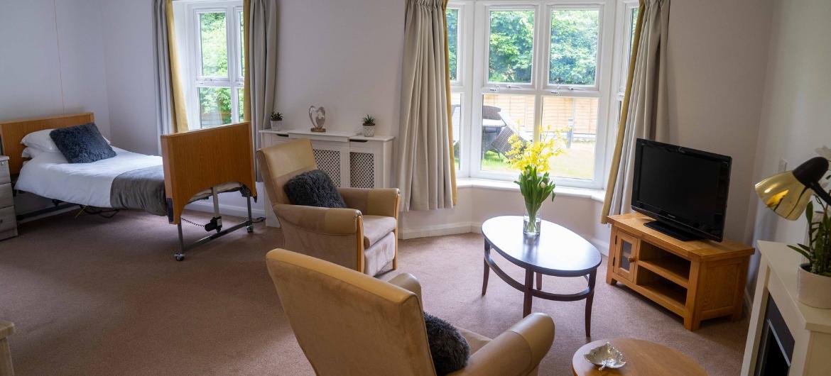 A large open plan bedroom with lounge area and tv