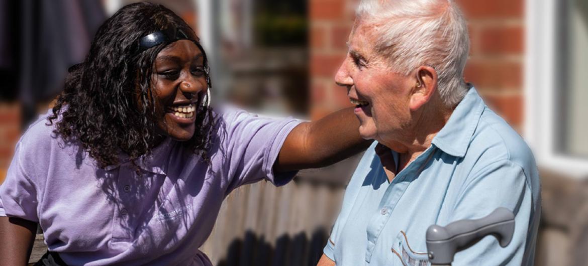 Care home worked smiling and laughing with care home resident.