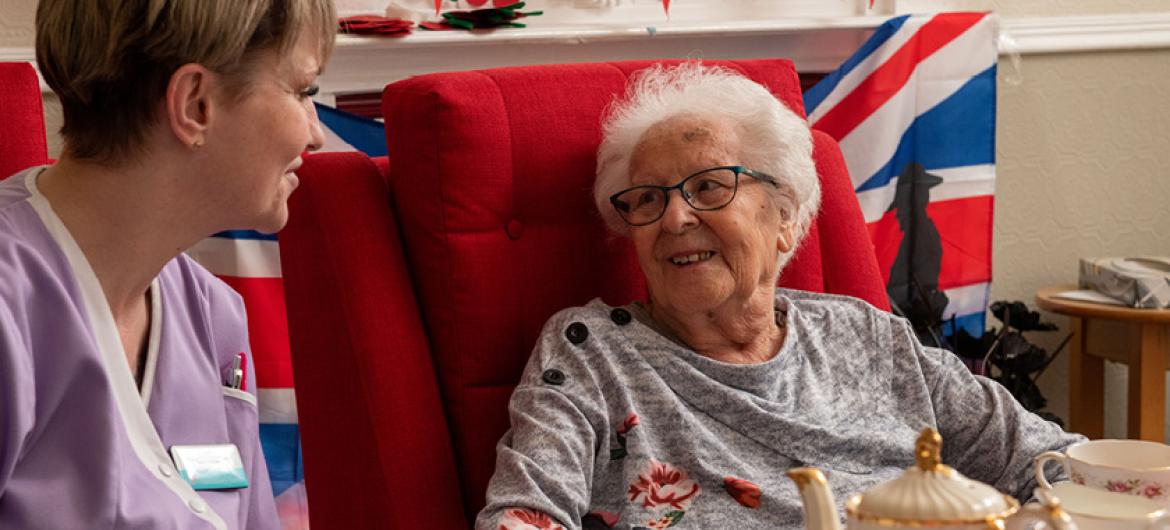 An elderly woman talking to a care home worker in a seat at the Redannick and Trevern care homes in Cornwall.
