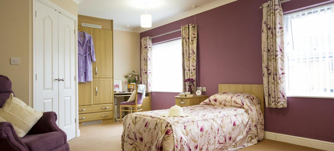 A light and airy bedroom with fitted wardrobes at The Beeches Residential Care Home.