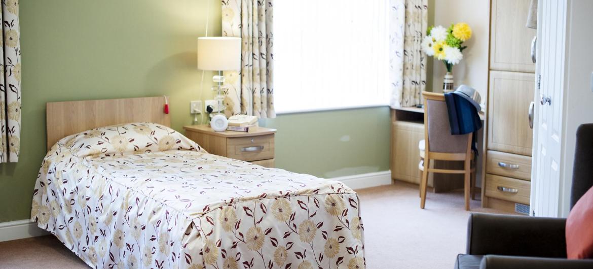 A pretty and airy bedroom at The Beeches Residential Care Home.