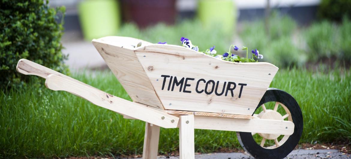 A wooden wheelbarrow in garden at Time Court Residential and Nursing Home.