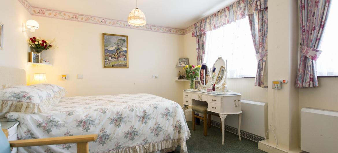 A pretty floral bedroom at Pinewood Residential Care Home.