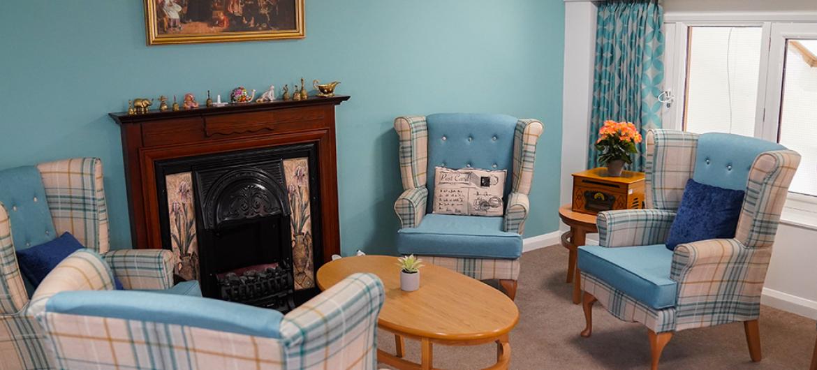 A lounge area with a blue theme at Bradwell Court